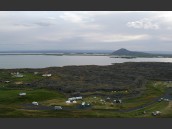 Sommarvy över campingplats, kyrkan och Myvatn på Island