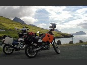 Två semesterpackade motorcyklar parkerade vid havet på Färöarna en sommarkväll.