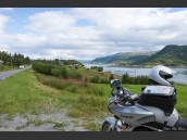 MC, Parkerad grå Kawasaki Versys 650 vid väg 812 i Nordland, Nordnorge, Norge i strålande sommarväder och sommarlandskap i bakgrunden.