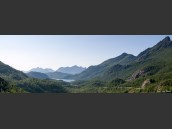 Vy med gröna berg och lite vatten utmed väg 820 mot Bø (Bö) på Vesterålen, Nordnorge, Norge.