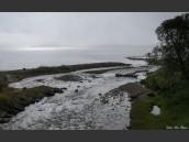 Bäck med trasig gammal båt. i motljus med dimma över havet som håller på att släppa i Nordland, Nordnorge, Norge.