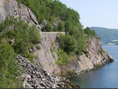 Brant bergssluttning med dramatiskt parti av gamla väg E6 och fjorden Rombak i Nordland, Norge.