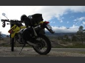 Parkerad DRZ 400 med dramatisk norsk himmel, moln och berg i bakgrunden.