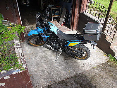 Garageinfart med ny betongplatta mellen spräckt mur, trappa och husgrund.